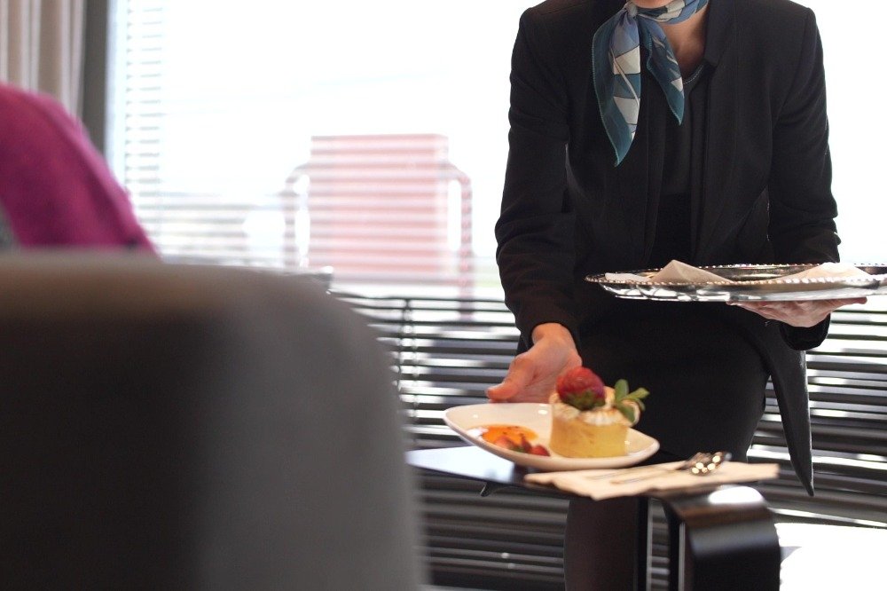 Sirviendo postre a pasajera en lounge